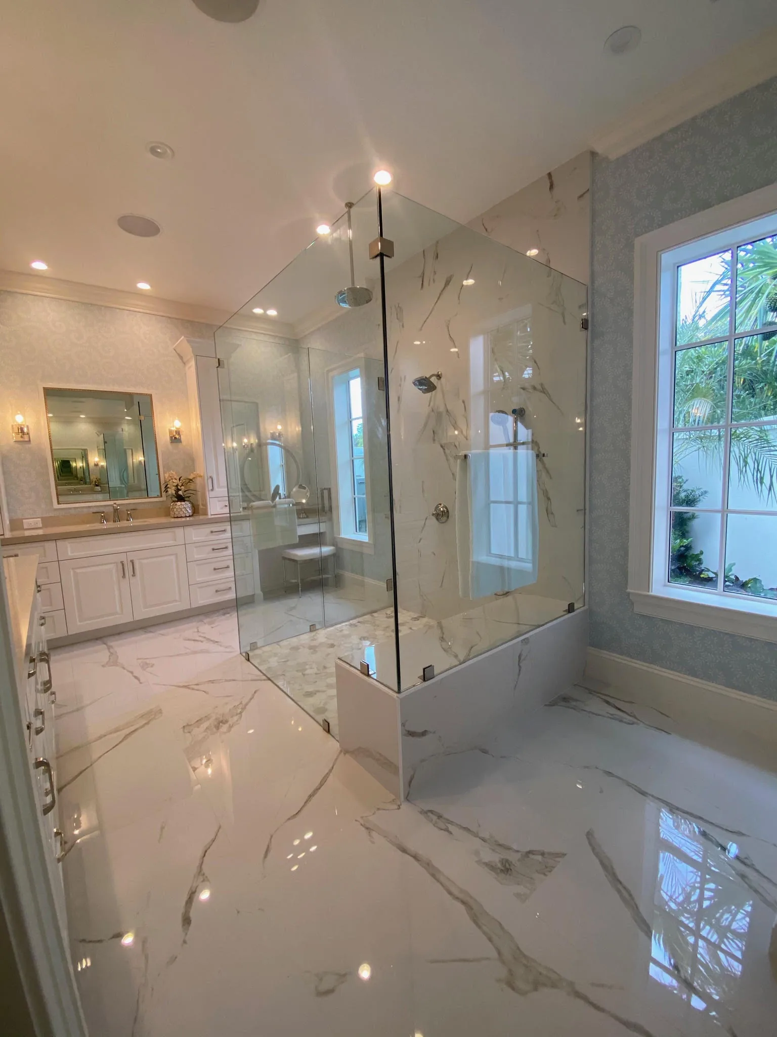 Bath with marble walls and a glass shower enclosure — Loxahatchee Club, Jupiter, FL