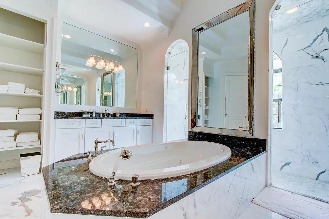 Bath with an oval tub and mirrored wall — Frenchman's Harbour, North Palm Beach, FL