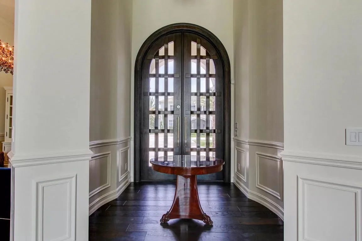 Entry with an arched iron door and wainscoting — Frenchman's Harbour, North Palm Beach, FL