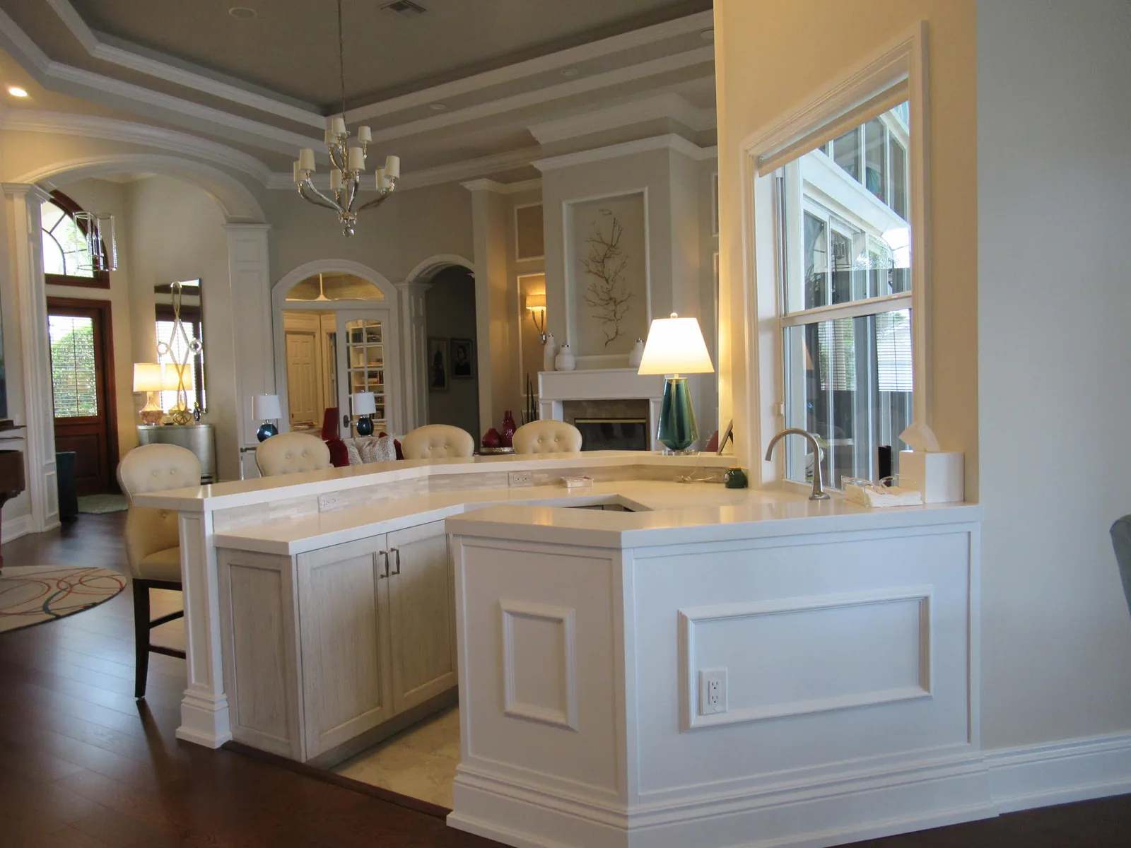 White kitchen opening onto the living room beneath a chandelier — Loxahatchee Club, Jupiter, FL