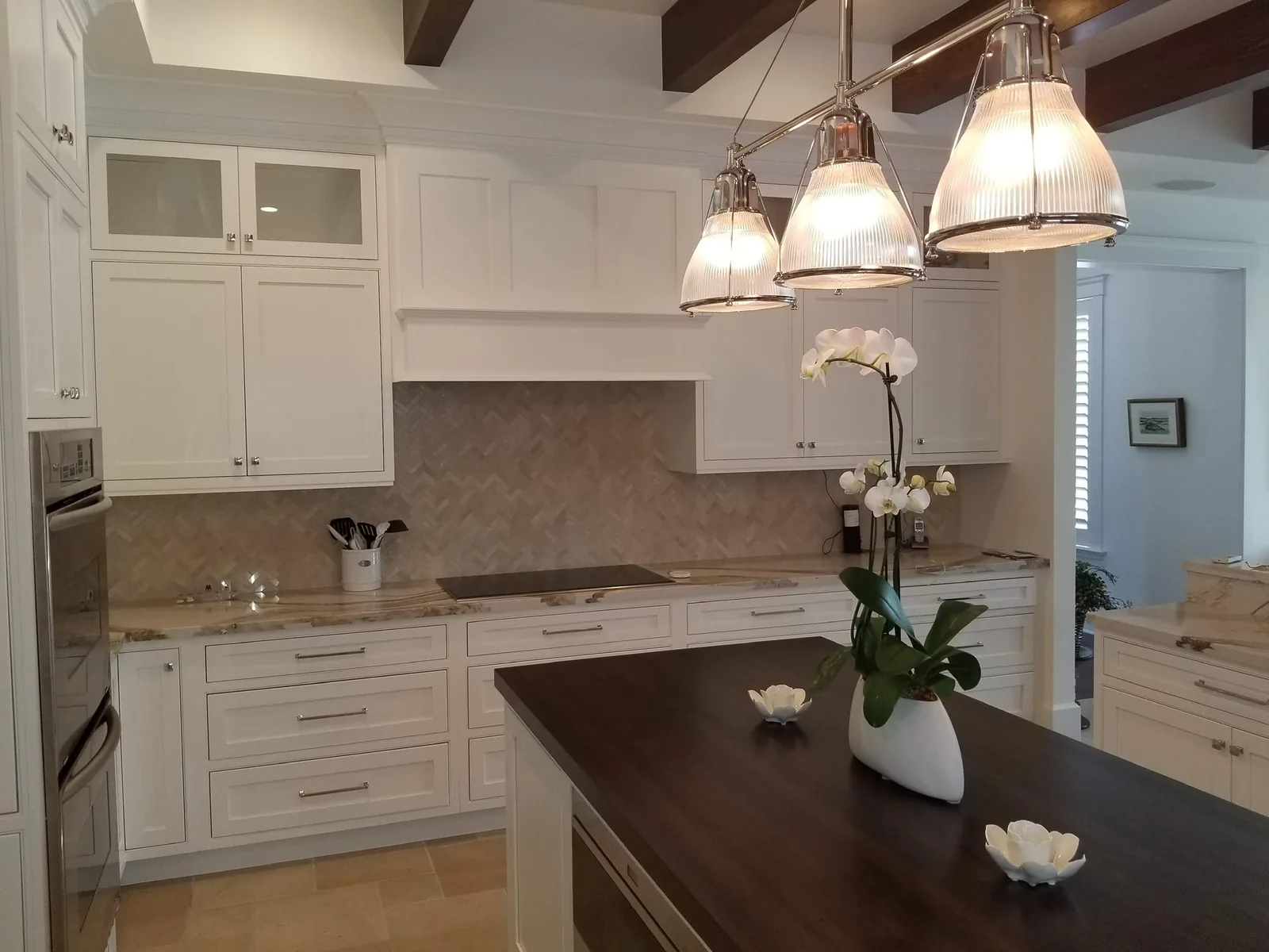 White kitchen with a herringbone backsplash and a dark wood island top — Loxahatchee Club, Jupiter, FL