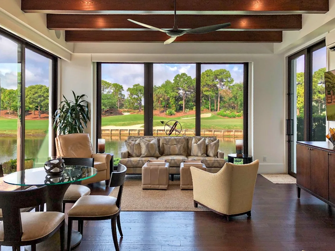 Living room with beamed ceiling and sliding doors onto a golf course — Loxahatchee Club, Jupiter, FL