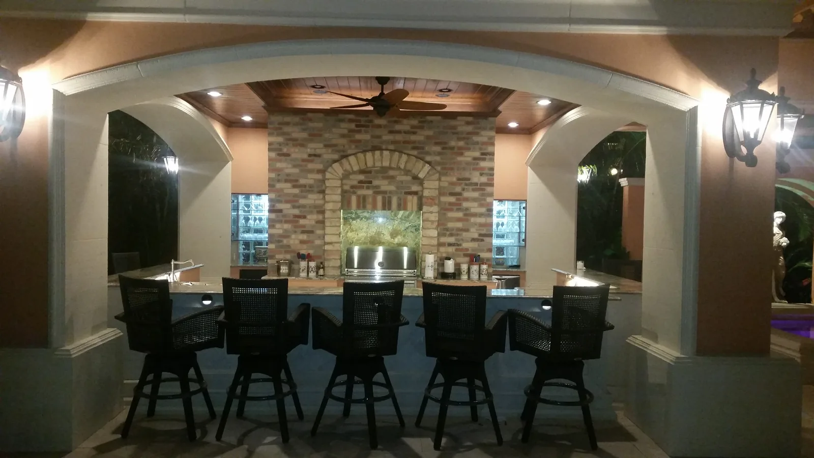 Covered outdoor bar with seating at night — Casa de Marbella, Palm Beach Gardens, FL