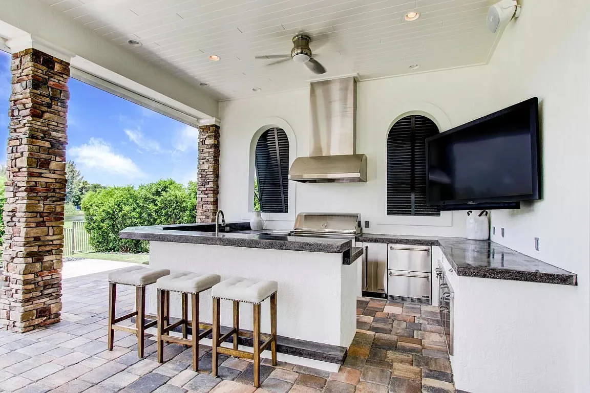 Covered outdoor kitchen with stone columns — Frenchman's Harbour, North Palm Beach, FL