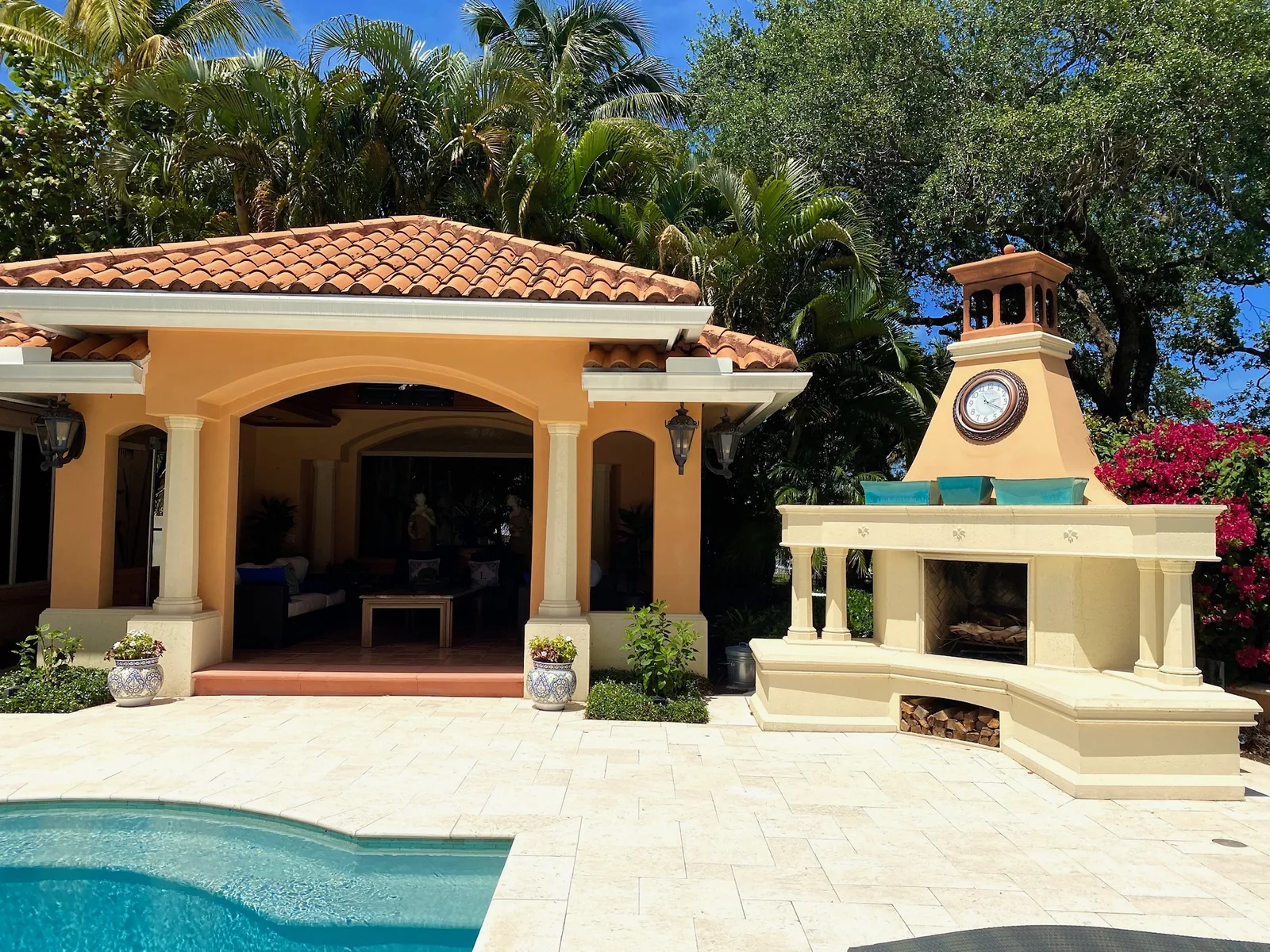 Pool house with an outdoor fireplace and tile roof — Casa de Marbella, Palm Beach Gardens, FL