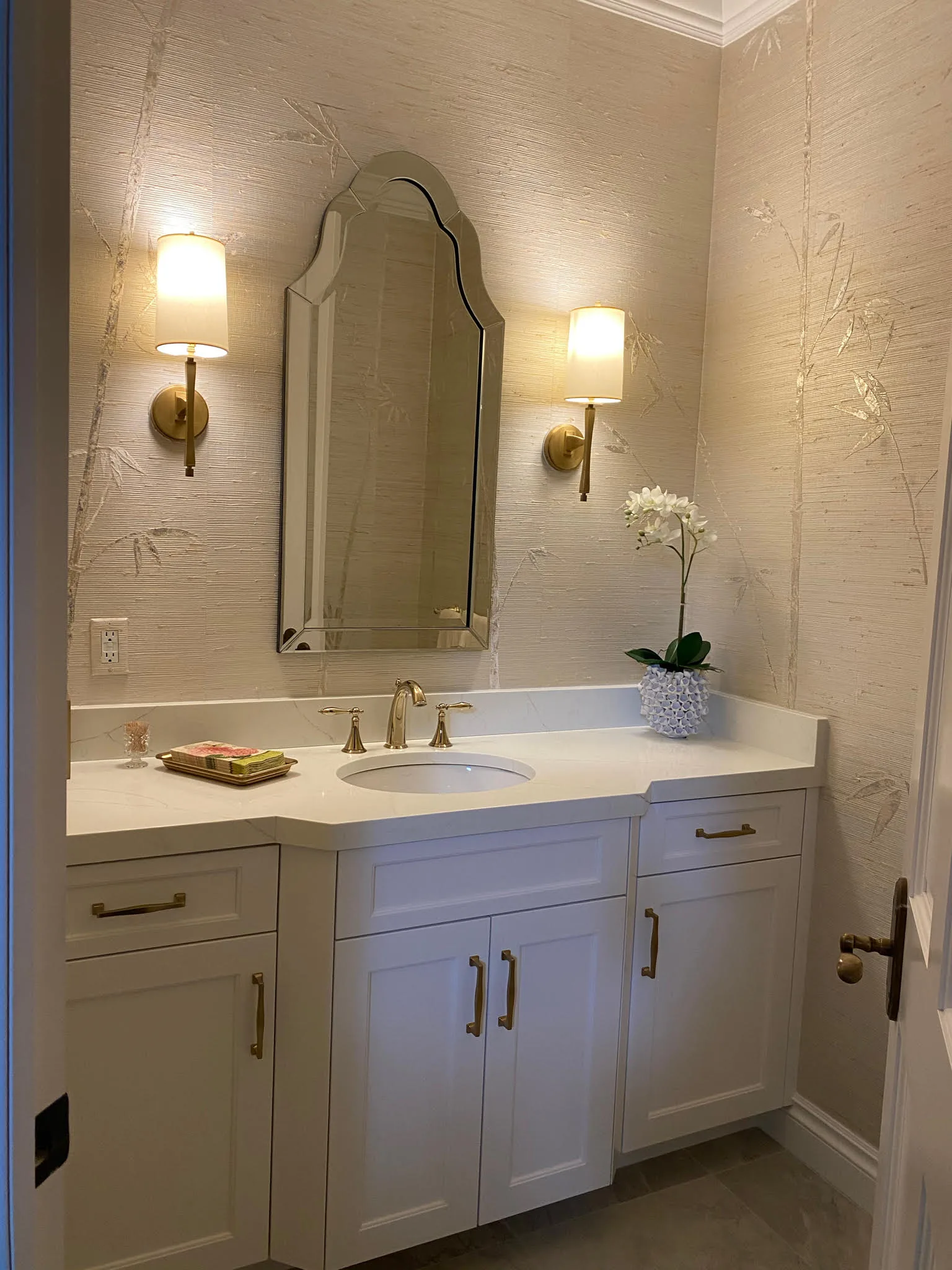 Powder bath with an arched mirror and brass sconces — Loxahatchee Club, Jupiter, FL