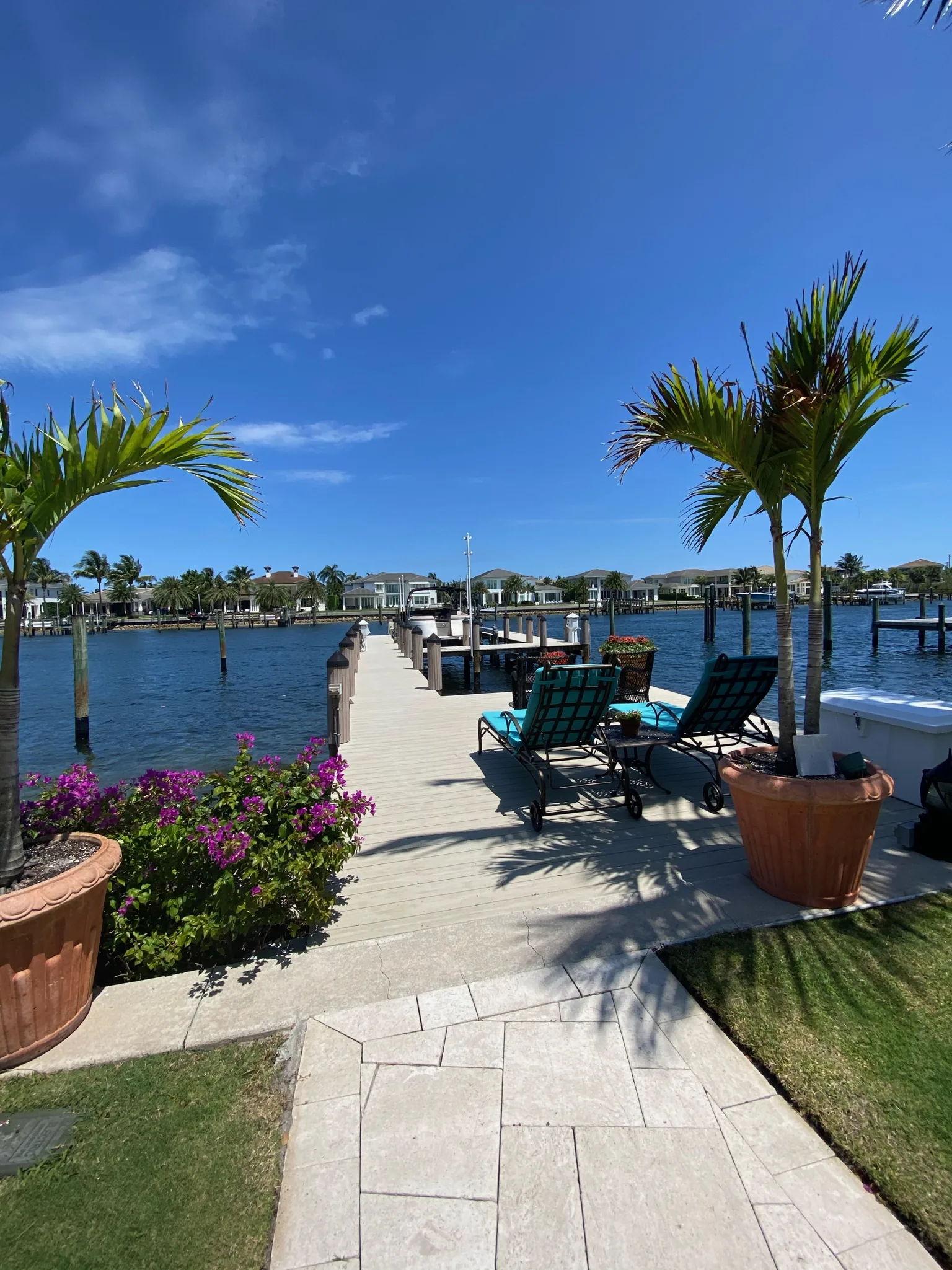 Walkway to a waterfront dock lined with palms — Casa de Marbella, Palm Beach Gardens, FL