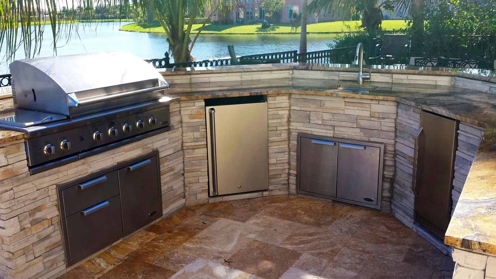 Outdoor kitchen with stone facing beside a lake in Jupiter, Florida
